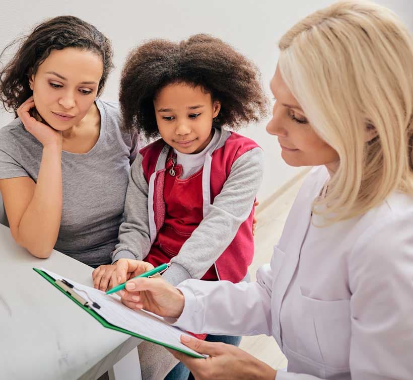 Two women and a child looking at a clipboard