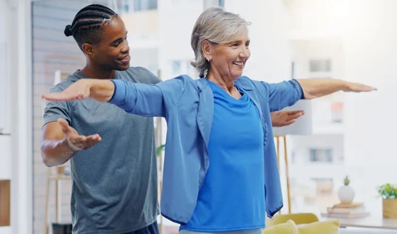 A nurse helping a woman with physical therapy